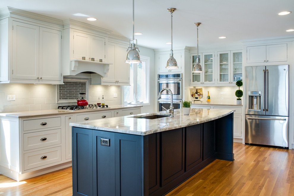 Inspiration for a huge contemporary l-shaped light wood floor eat-in kitchen remodel in Chicago with an undermount sink, recessed-panel cabinets, white cabinets, granite countertops, white backsplash, subway tile backsplash, stainless steel appliances and an island