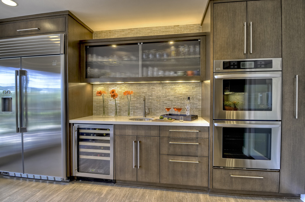Bild på ett mycket stort funkis kök, med rostfria vitvaror, en undermonterad diskho, släta luckor, grå skåp, bänkskiva i kvarts, vitt stänkskydd, stänkskydd i glaskakel, klinkergolv i porslin och en köksö