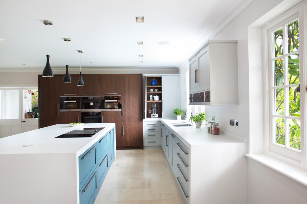 Immagine di una cucina minimal di medie dimensioni con lavello a doppia vasca, ante con riquadro incassato, ante blu, elettrodomestici in acciaio inossidabile, pavimento beige e top bianco