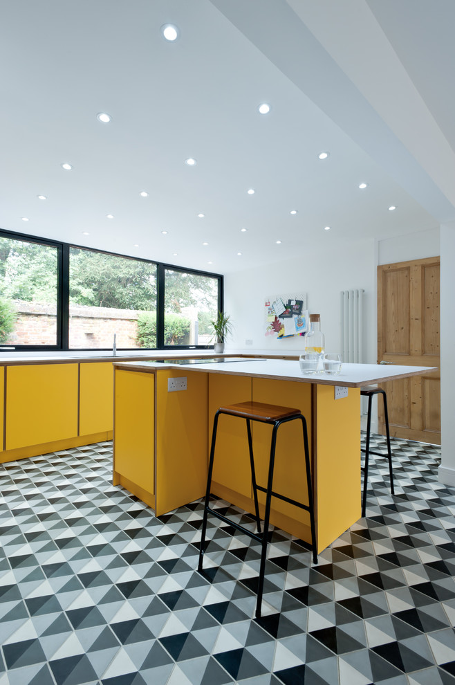 Imagen de cocina contemporánea de tamaño medio con armarios con paneles lisos, puertas de armario amarillas, encimera de laminado, una isla y encimeras blancas