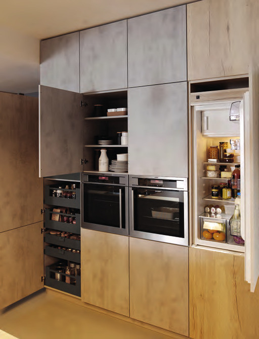 Modern inredning av ett stort linjärt kök med öppen planlösning, med släta luckor, skåp i ljust trä, laminatbänkskiva, svarta vitvaror, betonggolv, en köksö och grått golv