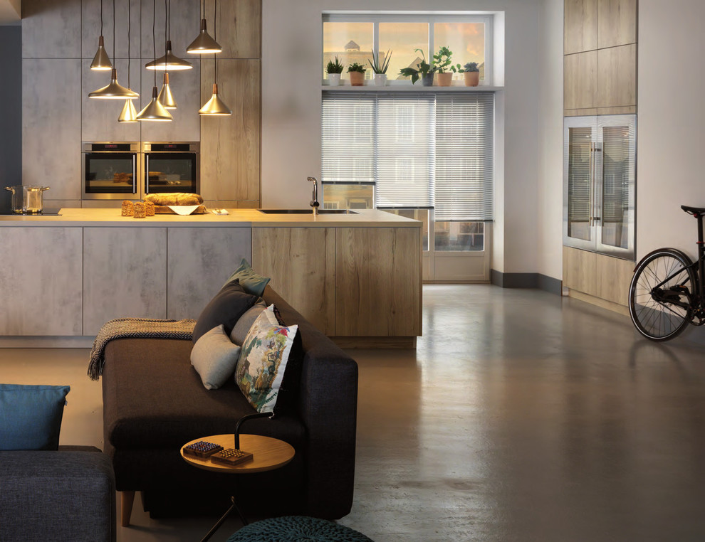Esempio di una grande cucina contemporanea con ante lisce, ante in legno chiaro, top in laminato, elettrodomestici neri, pavimento in cemento e pavimento grigio