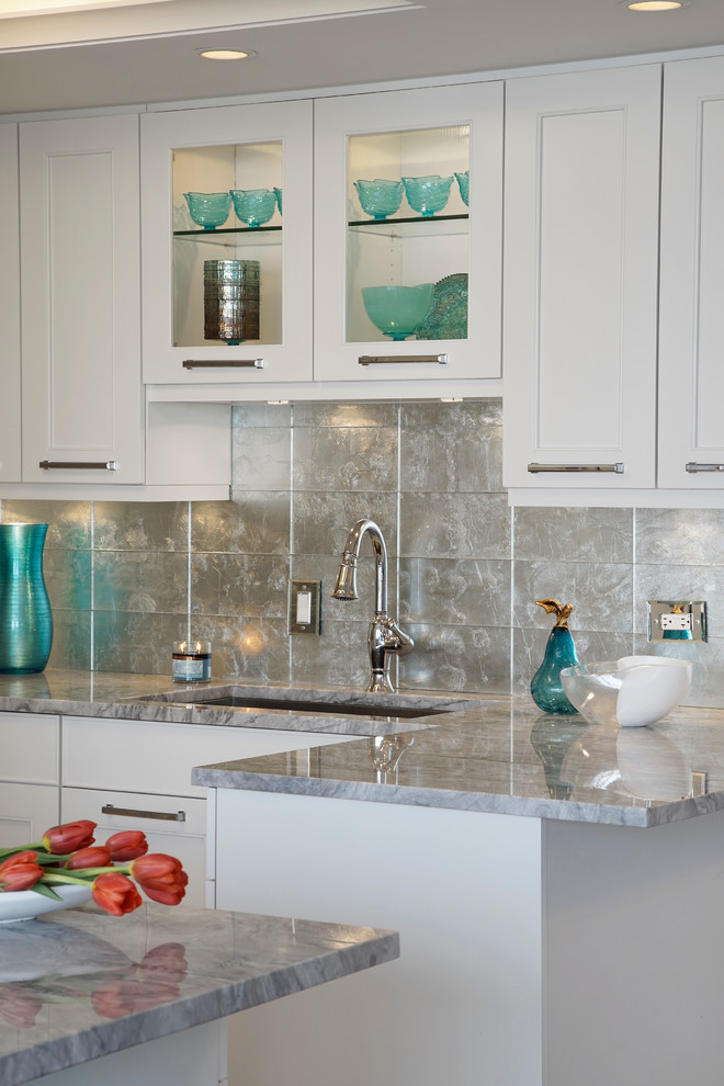 Inspiration for a small transitional u-shaped porcelain tile kitchen remodel in Chicago with a single-bowl sink, shaker cabinets, white cabinets, quartzite countertops, metallic backsplash, glass tile backsplash, stainless steel appliances and a peninsula
