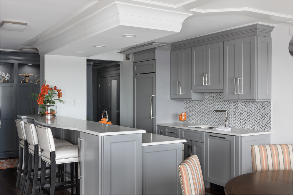 Photo of a small contemporary galley kitchen/diner in Newark with a submerged sink, shaker cabinets, grey cabinets, wood worktops, white splashback, marble splashback, integrated appliances, dark hardwood flooring, a breakfast bar, brown floors and white worktops.