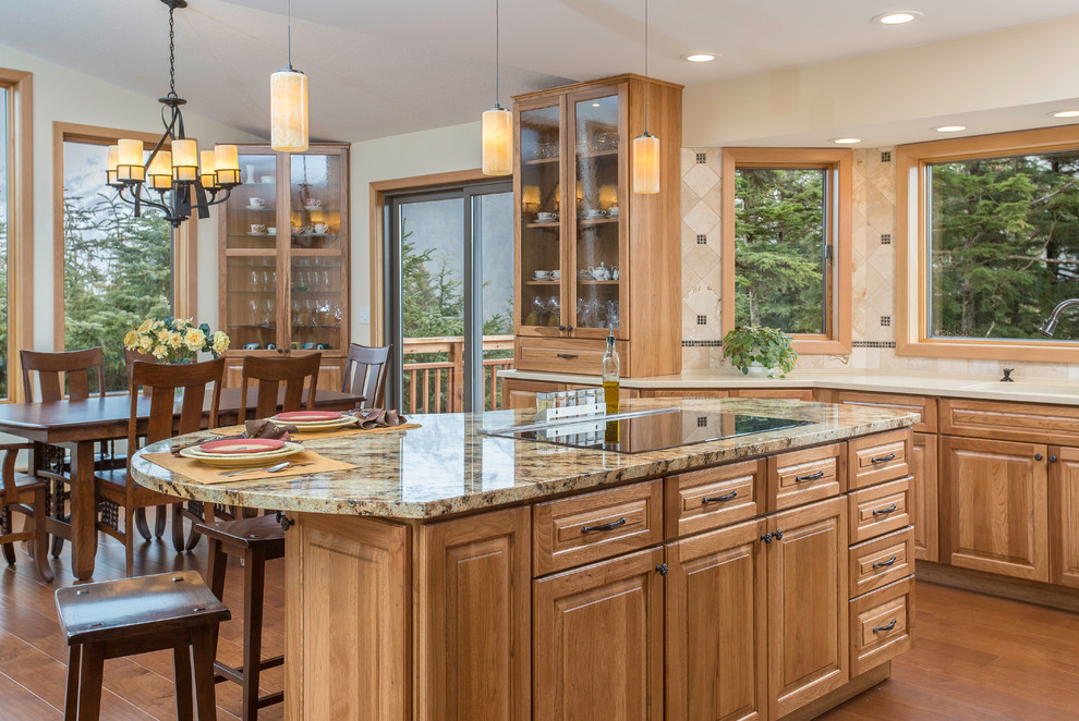 Eat-in kitchen - mid-sized eclectic l-shaped medium tone wood floor eat-in kitchen idea in Other with an undermount sink, raised-panel cabinets, medium tone wood cabinets, granite countertops, beige backsplash, stone tile backsplash, stainless steel appliances and an island
