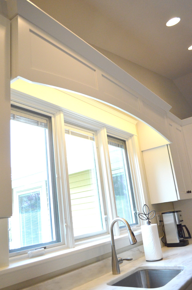 Bild på ett mellanstort funkis kök, med skåp i shakerstil, vita skåp, rostfria vitvaror, en köksö, marmorbänkskiva och mörkt trägolv