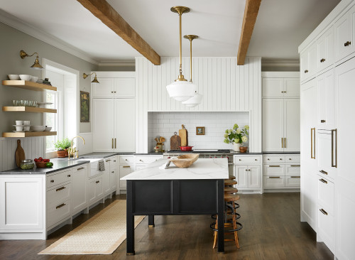 Premium RTA cabinets Canada – bright kitchen with white shaker cabinetry and brass hardware, black island with marble countertop, white subway tile backsplash, open wood shelves, wood ceiling beams, and pendant lights.