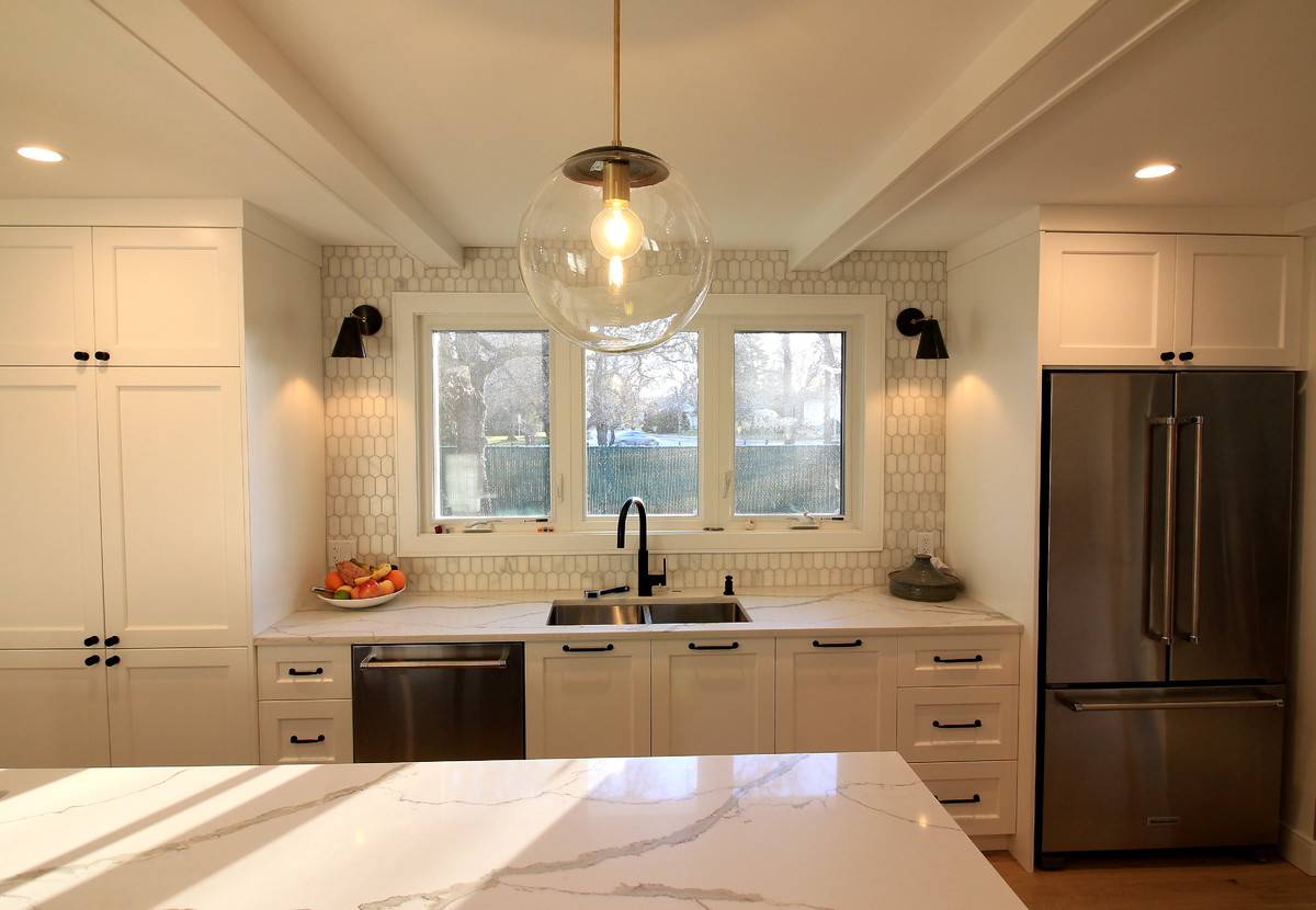 Inspiration för ett stort funkis kök, med en undermonterad diskho, skåp i shakerstil, vita skåp, bänkskiva i kvarts, vitt stänkskydd, stänkskydd i marmor, rostfria vitvaror, ljust trägolv, en köksö och beiget golv