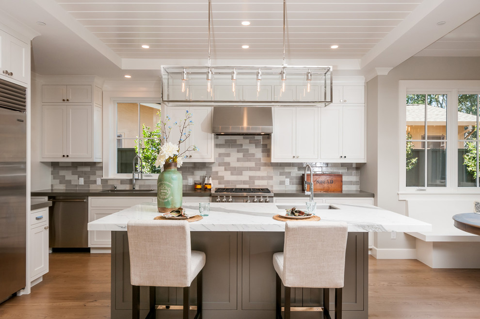 Klassische Küche mit Schrankfronten im Shaker-Stil, weißen Schränken, Kücheninsel, bunter Rückwand, Küchengeräten aus Edelstahl und hellem Holzboden in San Francisco