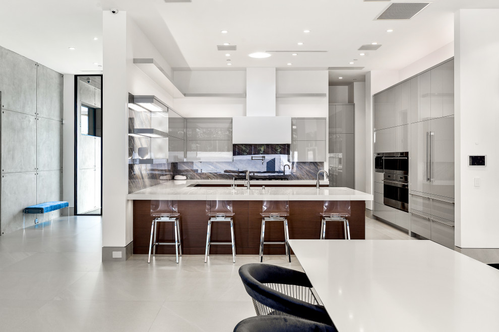 Foto di una cucina abitabile design con lavello da incasso, ante lisce, ante grigie, paraspruzzi multicolore, elettrodomestici in acciaio inossidabile, pavimento con piastrelle in ceramica, pavimento bianco e top bianco