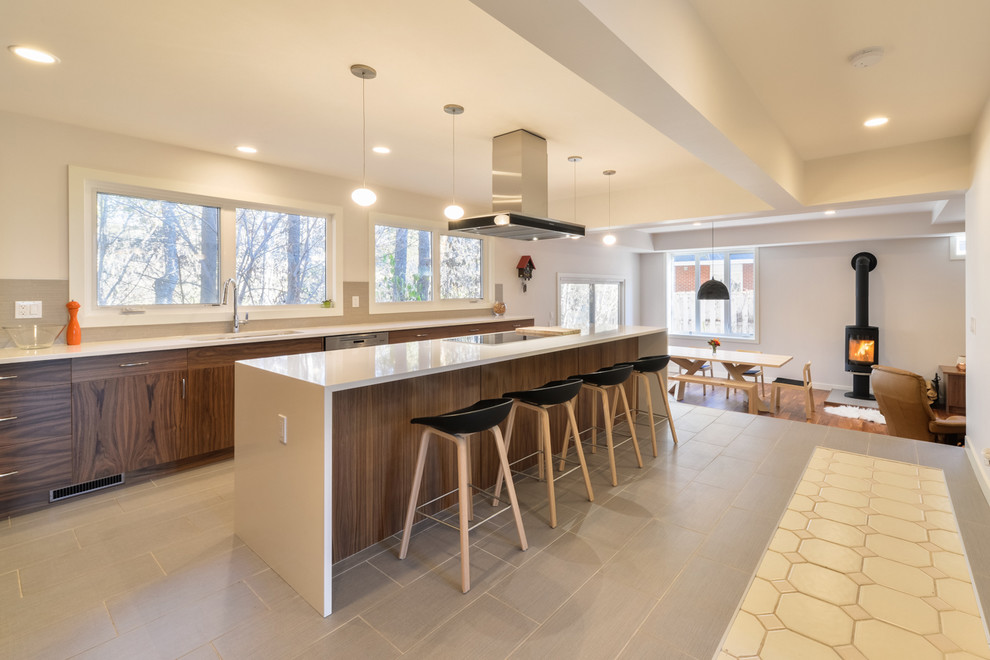 Inspiration for a mid-sized contemporary l-shaped porcelain tile and gray floor eat-in kitchen remodel in Calgary with an undermount sink, flat-panel cabinets, dark wood cabinets, solid surface countertops, gray backsplash, mosaic tile backsplash, stainless steel appliances and an island