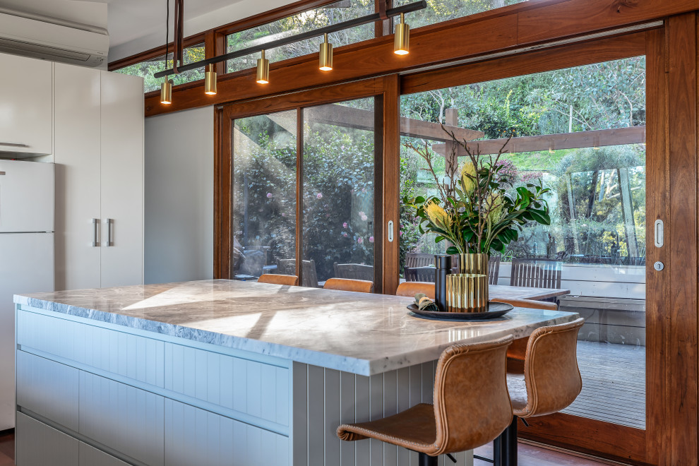 Cette image montre une grande cuisine ouverte design avec des portes de placards vertess, plan de travail en marbre, îlot et un plan de travail gris.