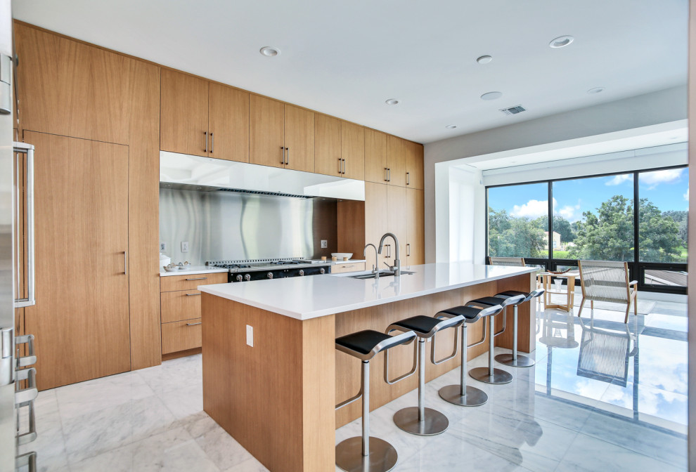 Inspiration for a large contemporary l-shaped kitchen/diner in Tampa with a submerged sink, flat-panel cabinets, light wood cabinets, quartz worktops, stainless steel appliances, marble flooring, an island, white floors and white worktops.