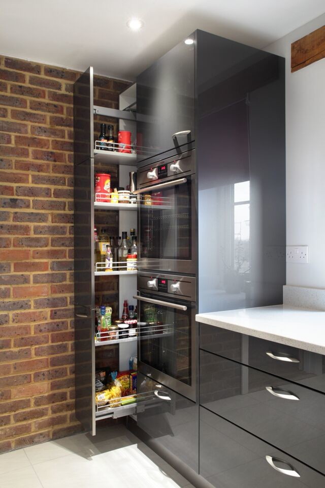 Inspiration for a large contemporary l-shaped kitchen/diner in Buckinghamshire with flat-panel cabinets, grey cabinets, red splashback, glass sheet splashback, stainless steel appliances, an island, an integrated sink, wood worktops and porcelain flooring.