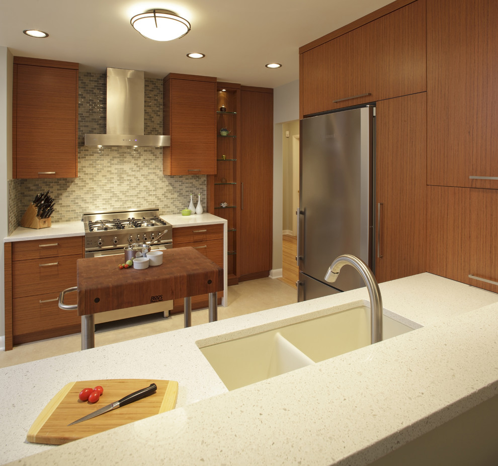 Moderne Küche mit Küchengeräten aus Edelstahl, Quarzwerkstein-Arbeitsplatte, Doppelwaschbecken und hellbraunen Holzschränken in Calgary
