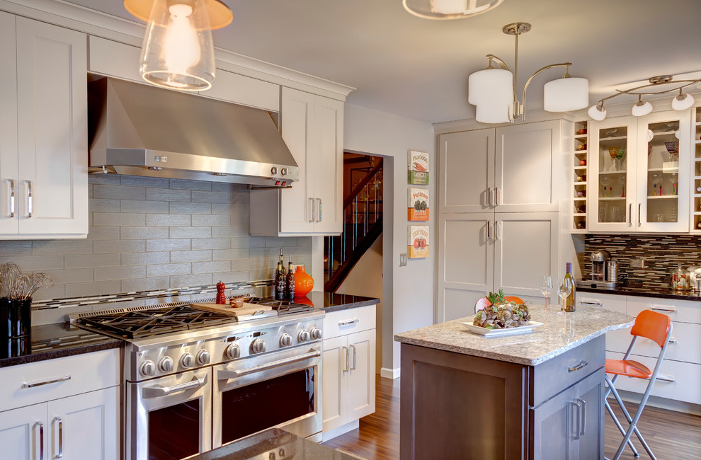 Eat-in kitchen - eclectic u-shaped eat-in kitchen idea in Chicago with an undermount sink, flat-panel cabinets, white cabinets, granite countertops, gray backsplash, glass tile backsplash and stainless steel appliances