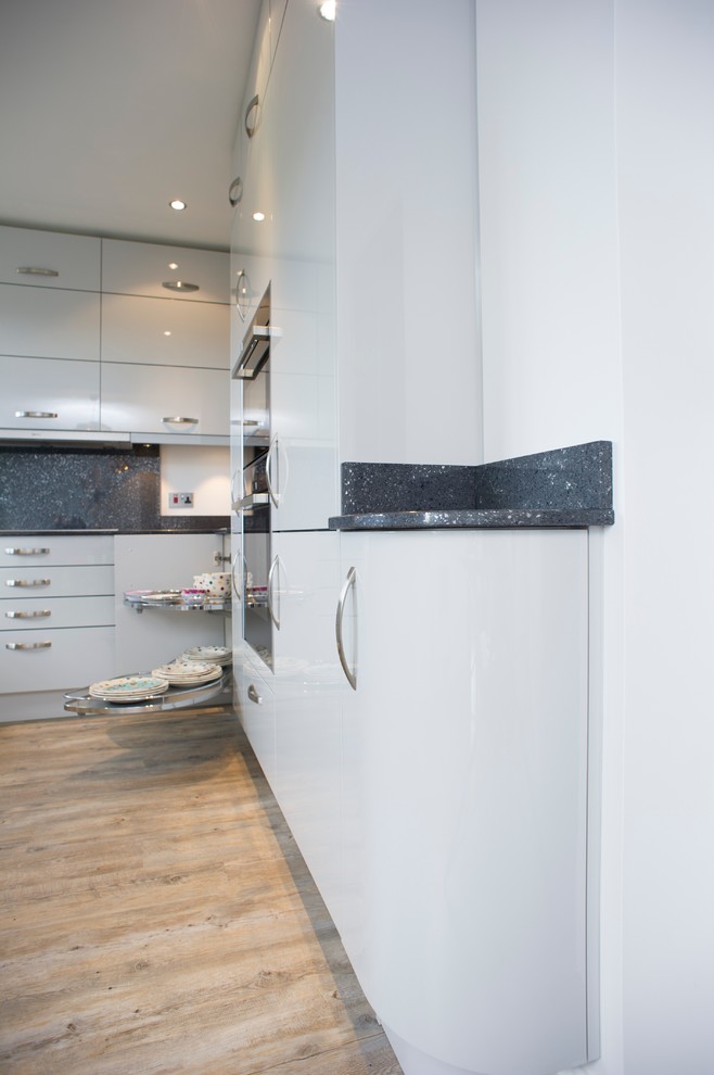 Inspiration for a medium sized contemporary u-shaped kitchen/diner in Other with an integrated sink, flat-panel cabinets, grey cabinets, quartz worktops, grey splashback and integrated appliances.
