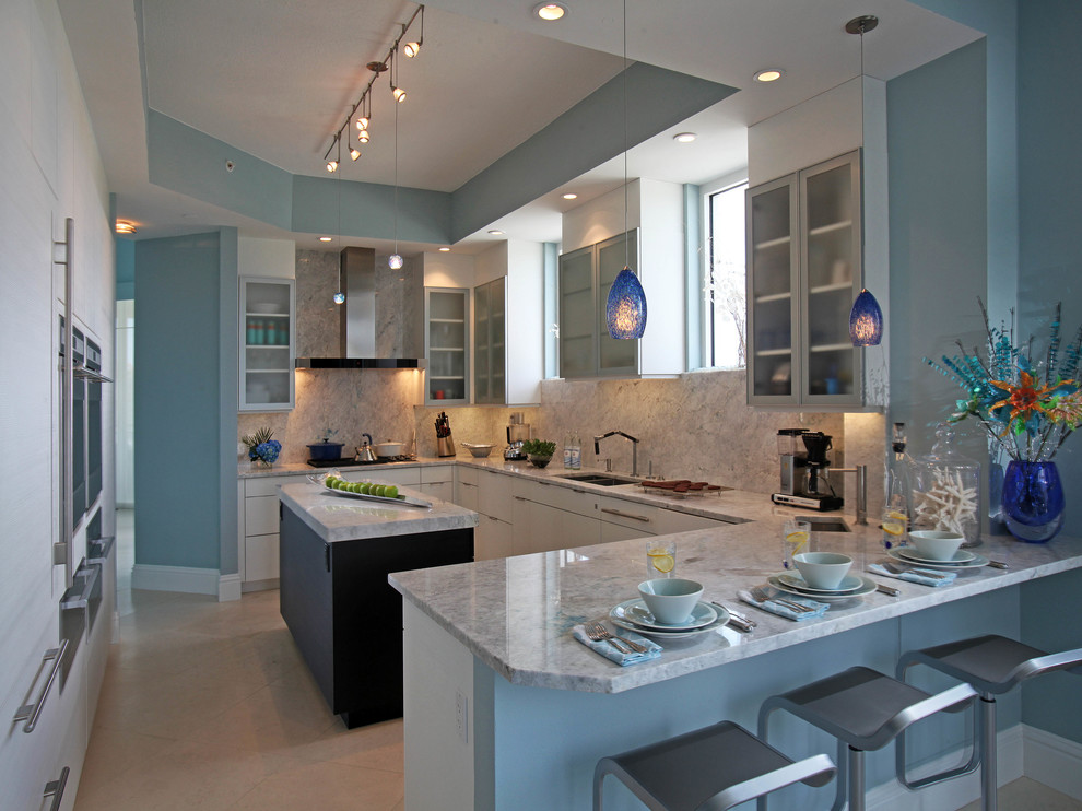 Example of a large trendy u-shaped porcelain tile eat-in kitchen design in Miami with flat-panel cabinets, white cabinets, granite countertops, stone slab backsplash, paneled appliances, an island, an undermount sink and gray backsplash