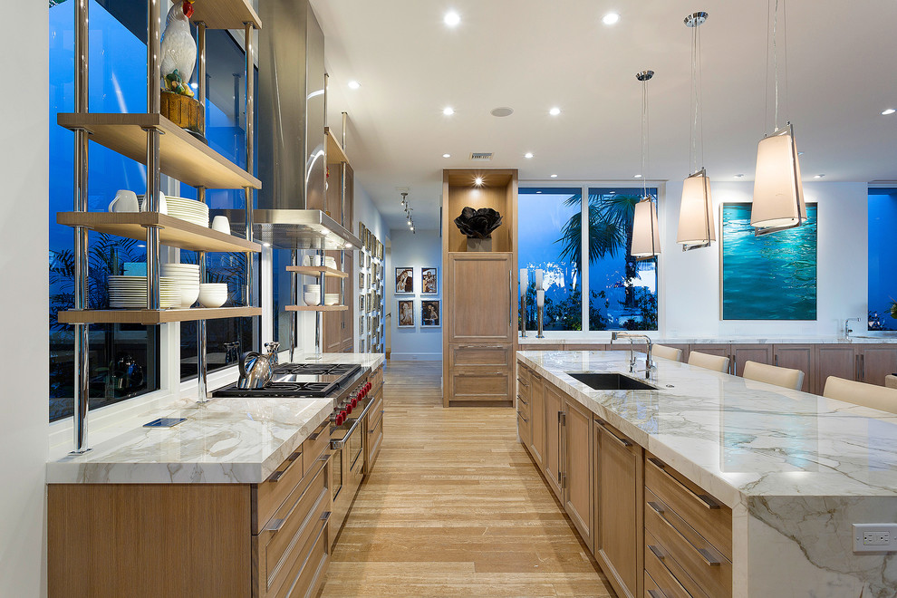 Contemporary galley open plan kitchen in Miami with a submerged sink, recessed-panel cabinets, light wood cabinets, integrated appliances, light hardwood flooring and an island.
