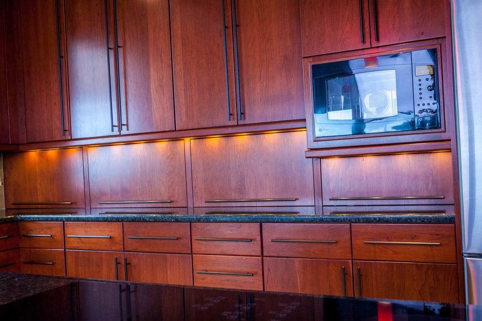 Große Moderne Wohnküche in L-Form mit Unterbauwaschbecken, flächenbündigen Schrankfronten, hellbraunen Holzschränken, Quarzwerkstein-Arbeitsplatte, Küchenrückwand in Rot, Glasrückwand, Küchengeräten aus Edelstahl, Porzellan-Bodenfliesen und Kücheninsel in Seattle
