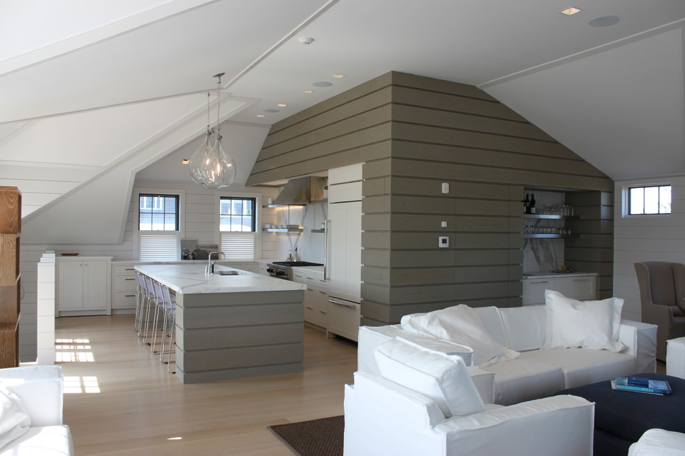 На фото: угловая, серо-белая кухня-гостиная в морском стиле с мраморной столешницей, белым фартуком и фартуком из каменной плиты с