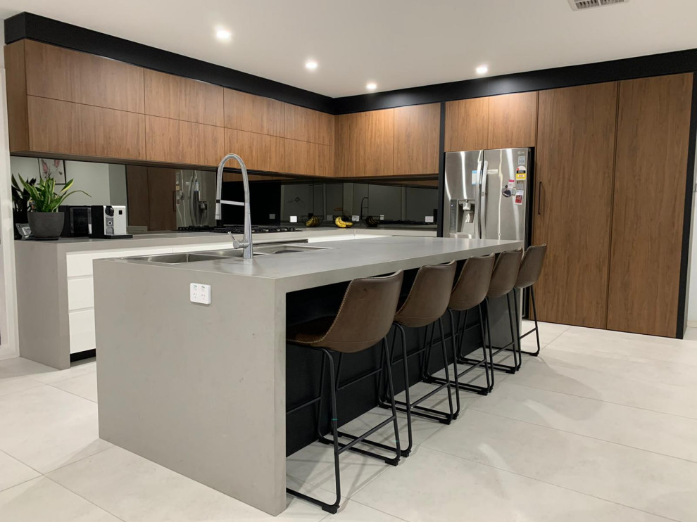 Design ideas for a medium sized modern galley kitchen/diner in Sydney with a double-bowl sink, flat-panel cabinets, white cabinets, marble worktops, black splashback, mirror splashback, black appliances, an island and grey worktops.