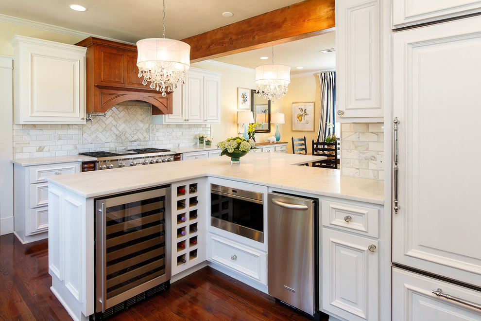 Example of a country dark wood floor and brown floor kitchen design in New Orleans with flat-panel cabinets, white cabinets, marble countertops, white backsplash, brick backsplash and stainless steel appliances