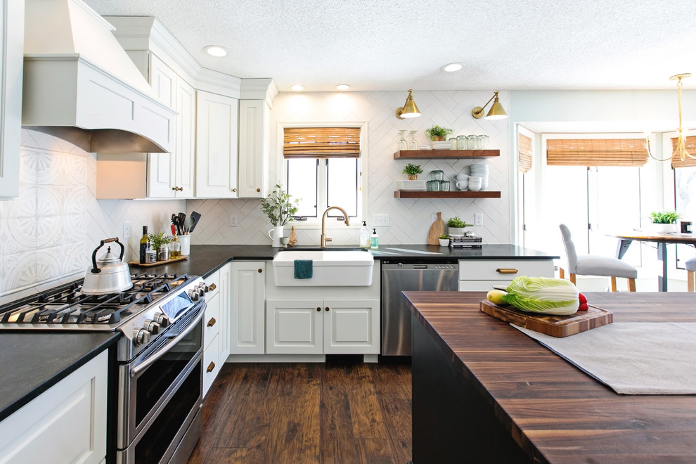 Bild på ett stort eklektiskt brun brunt kök, med en rustik diskho, skåp i shakerstil, vita skåp, träbänkskiva, vitt stänkskydd, stänkskydd i porslinskakel, rostfria vitvaror, mörkt trägolv, en köksö och brunt golv