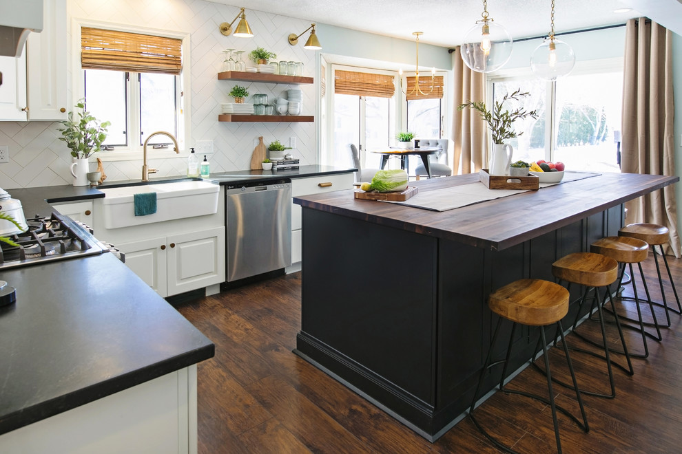 Example of a large eclectic l-shaped dark wood floor and brown floor open concept kitchen design in Atlanta with a farmhouse sink, shaker cabinets, white cabinets, wood countertops, white backsplash, porcelain backsplash, stainless steel appliances, an island and brown countertops