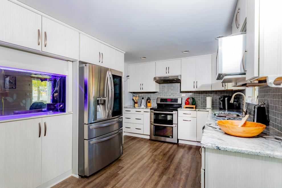 Foto di una cucina ad U contemporanea di medie dimensioni con elettrodomestici in acciaio inossidabile e pavimento in legno massello medio