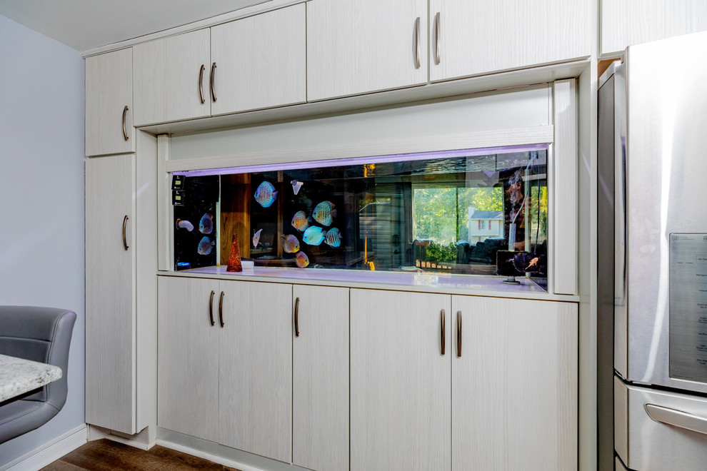 Diseño de cocinas en U actual de tamaño medio con electrodomésticos de acero inoxidable y suelo de madera en tonos medios