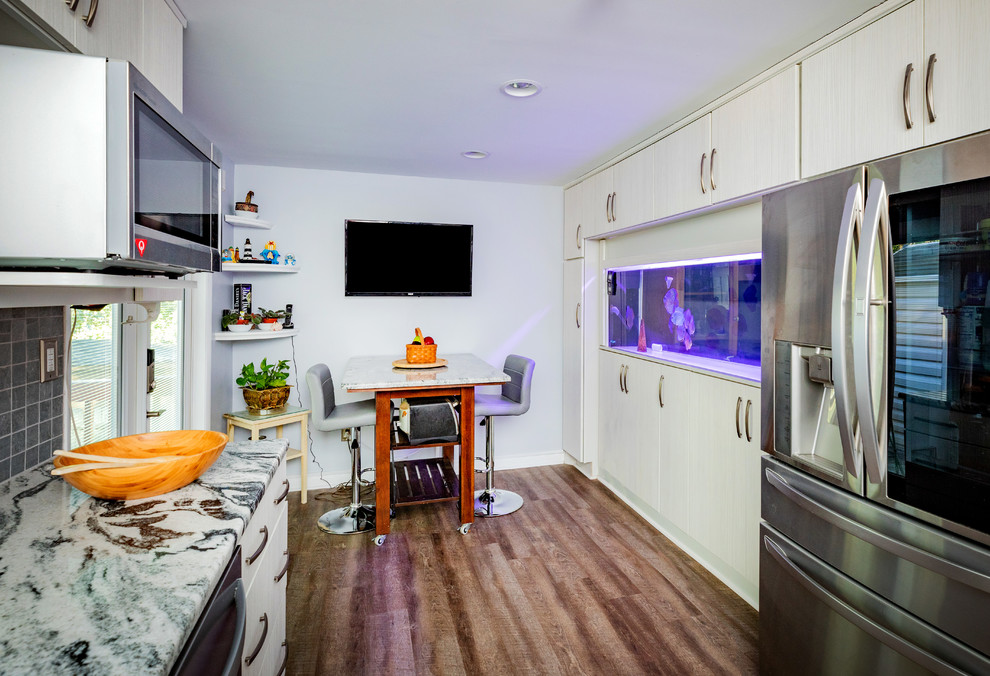Mittelgroße Moderne Küche in U-Form mit Unterbauwaschbecken, Küchengeräten aus Edelstahl und braunem Holzboden in Richmond