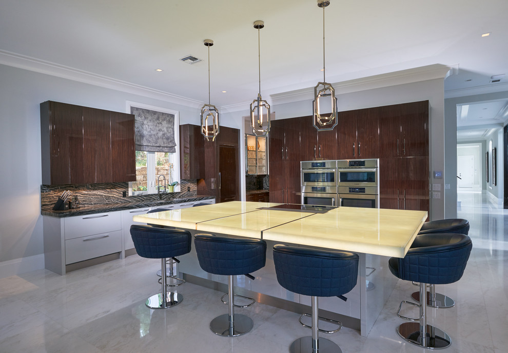Huge trendy l-shaped marble floor open concept kitchen photo in Miami with an undermount sink, flat-panel cabinets, dark wood cabinets, glass countertops, black backsplash, stone slab backsplash, stainless steel appliances and an island