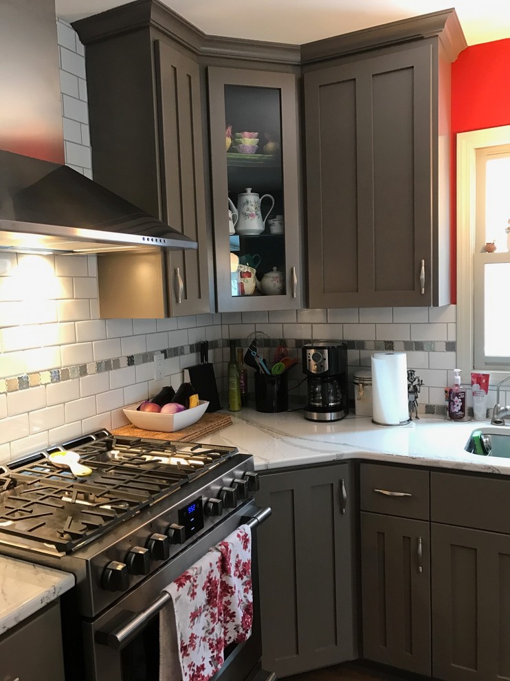 Photo of a medium sized classic u-shaped kitchen/diner in New York with a single-bowl sink, shaker cabinets, grey cabinets, marble worktops, white splashback, metro tiled splashback, stainless steel appliances, medium hardwood flooring and an island.