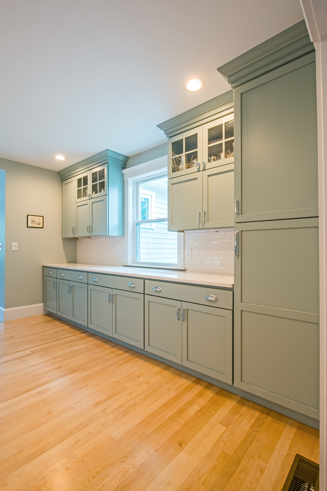 Photo of a large traditional kitchen in Boston with shaker cabinets, white cabinets, blue splashback, stainless steel appliances, light hardwood flooring, no island and brown floors.