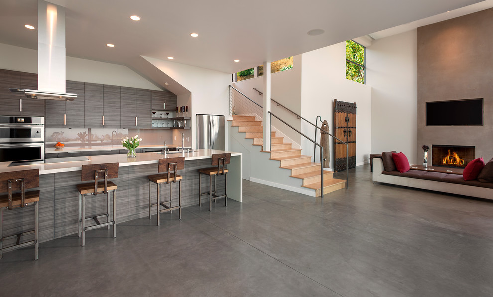 Inspiration for a mid-sized contemporary galley concrete floor eat-in kitchen remodel in Santa Barbara with an undermount sink, flat-panel cabinets, medium tone wood cabinets, quartz countertops, white backsplash, white appliances, an island and glass sheet backsplash