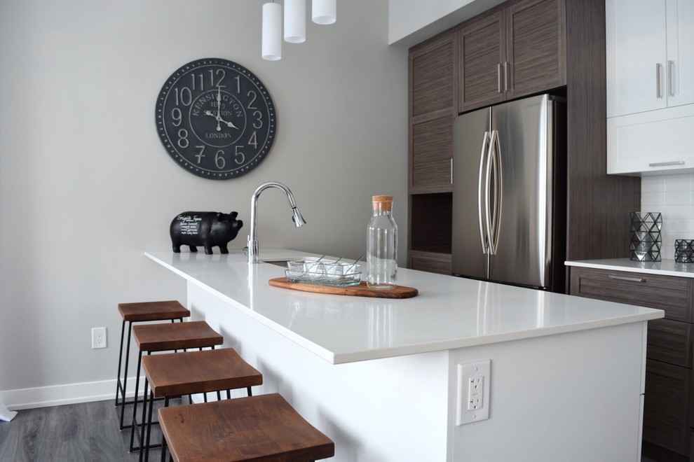Design ideas for a medium sized traditional single-wall kitchen/diner in Ottawa with a double-bowl sink, shaker cabinets, dark wood cabinets, composite countertops, white splashback, ceramic splashback, stainless steel appliances, ceramic flooring and an island.