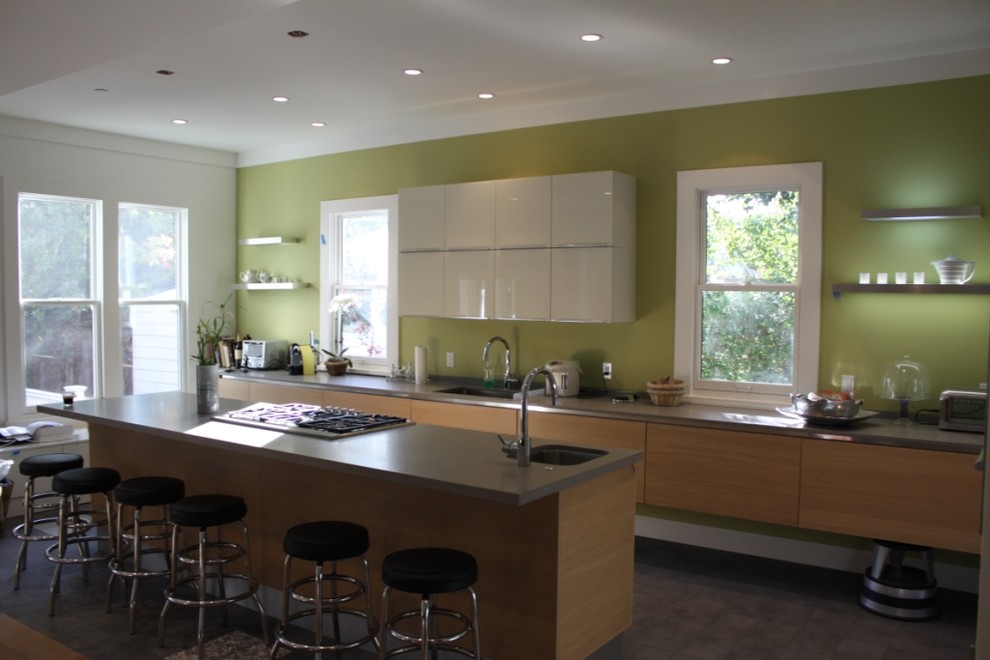 Immagine di una grande cucina moderna con lavello sottopiano, nessun'anta, ante in legno scuro, top in pietra calcarea, paraspruzzi verde, paraspruzzi in gres porcellanato, elettrodomestici in acciaio inossidabile, pavimento in cementine e pavimento marrone
