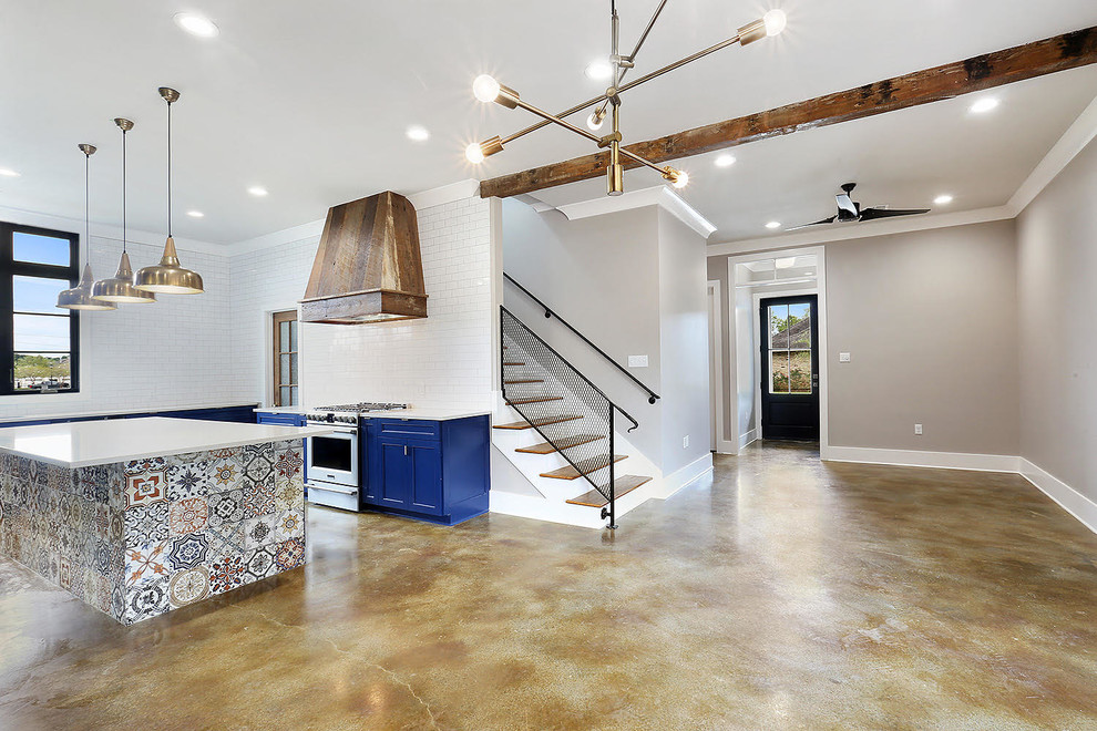 Mid-sized trendy u-shaped concrete floor and beige floor open concept kitchen photo in New Orleans with an undermount sink, recessed-panel cabinets, blue cabinets, solid surface countertops, white backsplash, subway tile backsplash, stainless steel appliances and an island