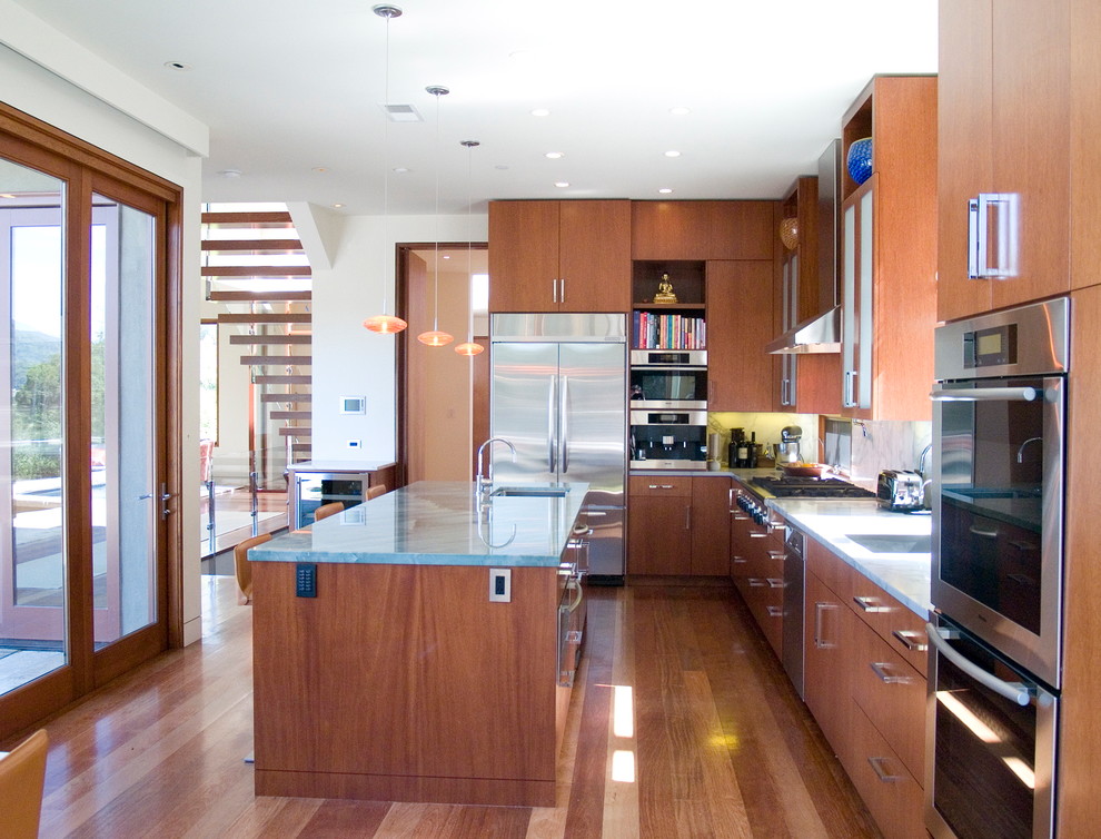 Idée de décoration pour une cuisine design en bois brun avec un électroménager en acier inoxydable et un placard à porte plane.