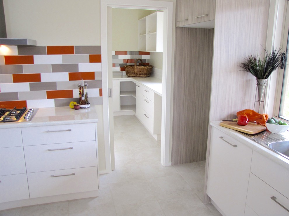 Modern inredning av ett mellanstort kök, med en dubbel diskho, skåp i shakerstil, vita skåp, laminatbänkskiva, flerfärgad stänkskydd, stänkskydd i keramik, rostfria vitvaror, klinkergolv i keramik och en köksö