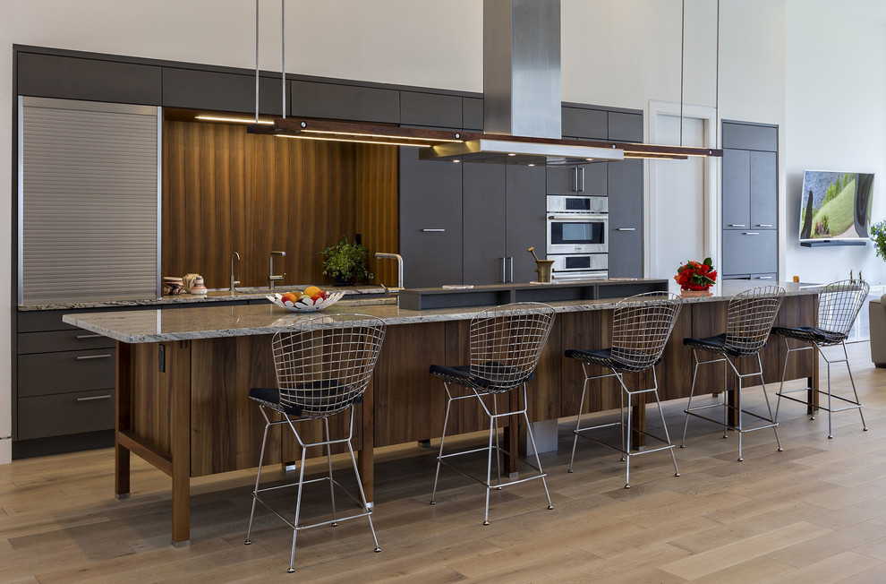 Moderne Küche mit grauen Schränken, Granit-Arbeitsplatte und Kücheninsel in Miami