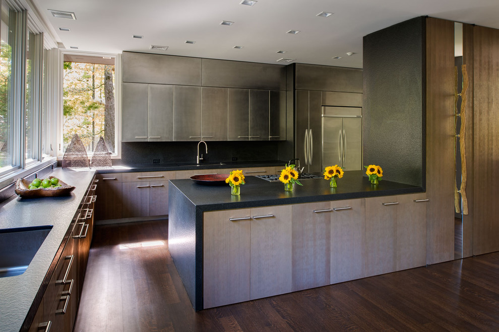 Contemporary l-shaped kitchen in New York with a submerged sink, flat-panel cabinets, medium wood cabinets, stainless steel appliances, dark hardwood flooring and a breakfast bar.
