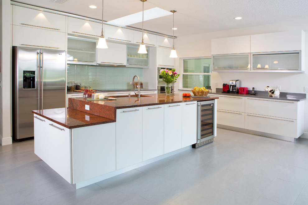 Moderne Küche in L-Form mit Unterbauwaschbecken, flächenbündigen Schrankfronten, weißen Schränken, Küchenrückwand in Grau, Küchengeräten aus Edelstahl und Kücheninsel in Orlando