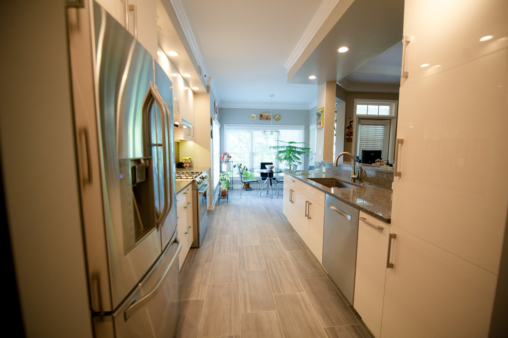 This is an example of a small contemporary galley kitchen/diner in Atlanta with a submerged sink, flat-panel cabinets, white cabinets, engineered stone countertops, glass tiled splashback, stainless steel appliances, travertine flooring and no island.