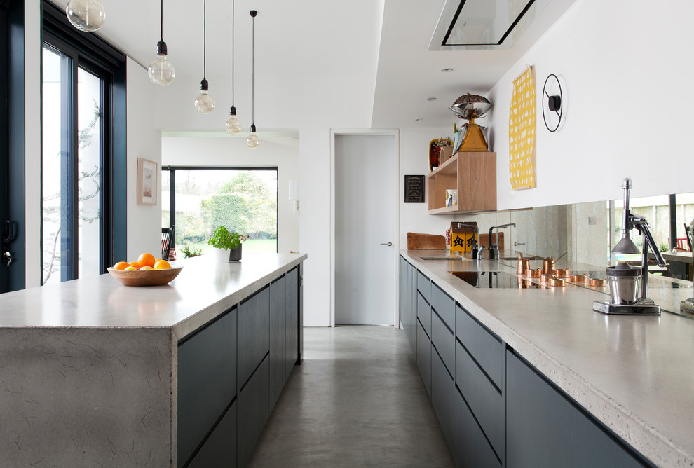 Photo of a contemporary kitchen in Other with flat-panel cabinets, black cabinets, mirror splashback, an island and grey worktops.
