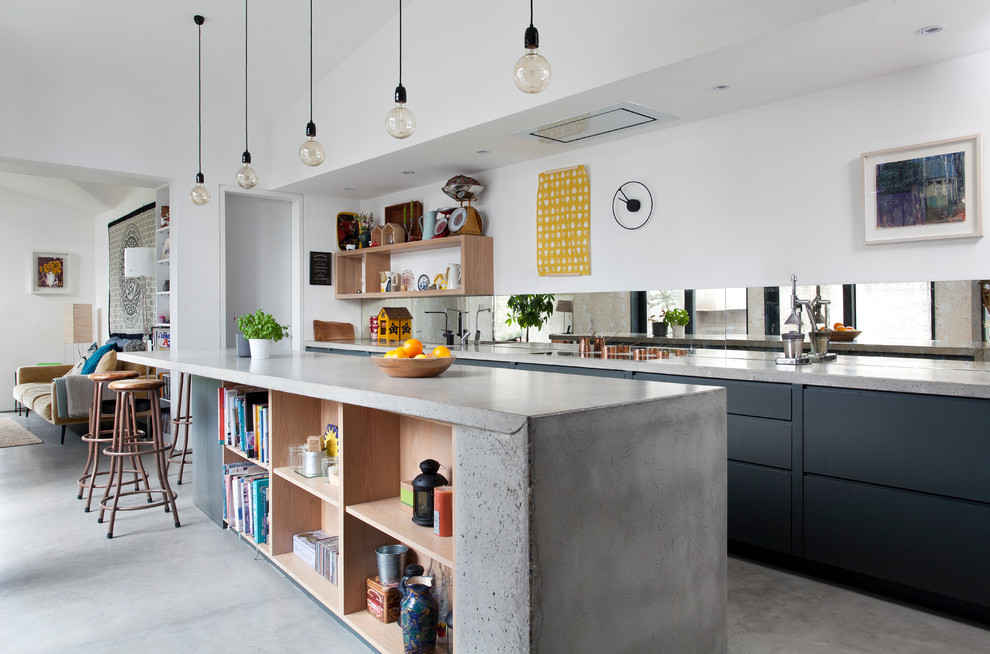 Open concept kitchen - large contemporary concrete floor and gray floor open concept kitchen idea in Other with black cabinets, concrete countertops, mirror backsplash, an island, gray countertops and flat-panel cabinets