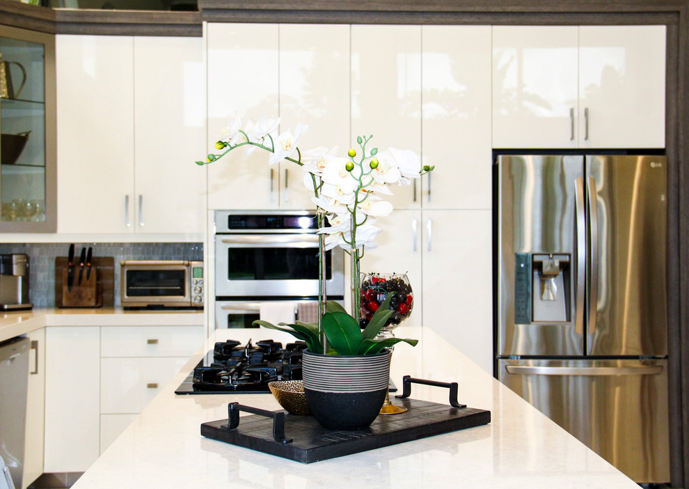 Inspiration för mellanstora moderna kök, med luckor med glaspanel, vita skåp, grått stänkskydd, en undermonterad diskho, bänkskiva i kvarts, stänkskydd i glaskakel, rostfria vitvaror, marmorgolv, en köksö och beiget golv