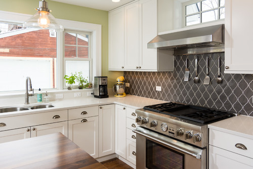 Kitchen and Bathroom Cabinets: white shaker kitchen with quartz counters, arabesque gray backsplash, stainless pro range, and undermount sink.