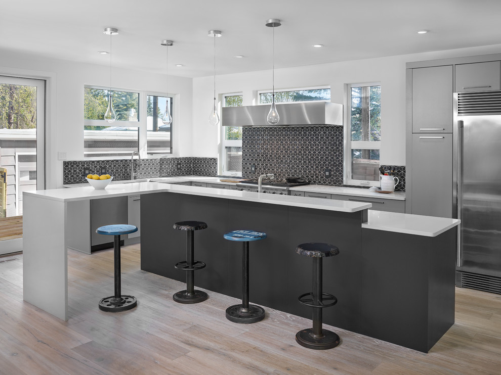 Mittelgroße Moderne Küche in L-Form mit flächenbündigen Schrankfronten, bunter Rückwand, Küchengeräten aus Edelstahl, hellem Holzboden und Kücheninsel in Edmonton